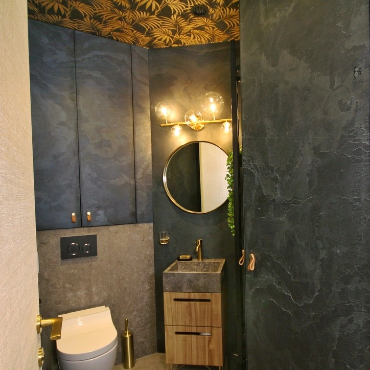 Les toilettes indépendantes avec leur vasque, leur miroir et leurs appliques.